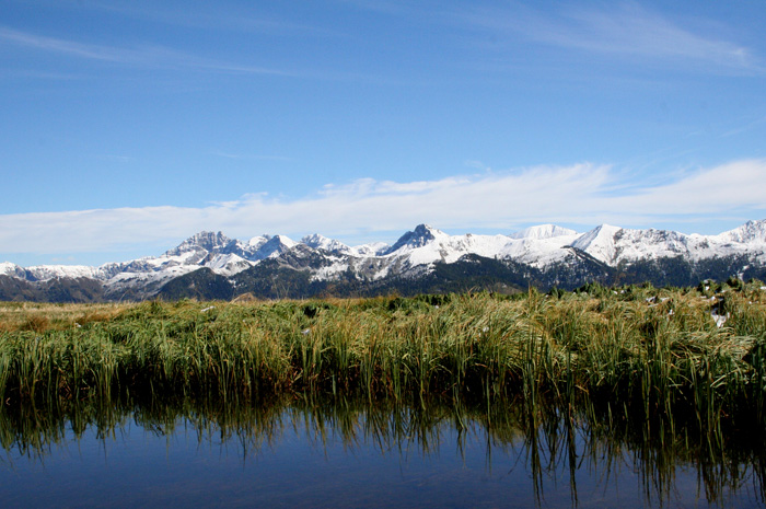 Bergsee mit schneebedeckten Gebirge im Hintergrund