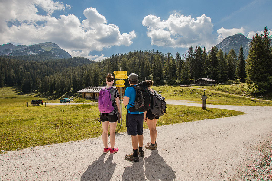 Eine Gruppe Wanderer blicken auf die Wegschilder