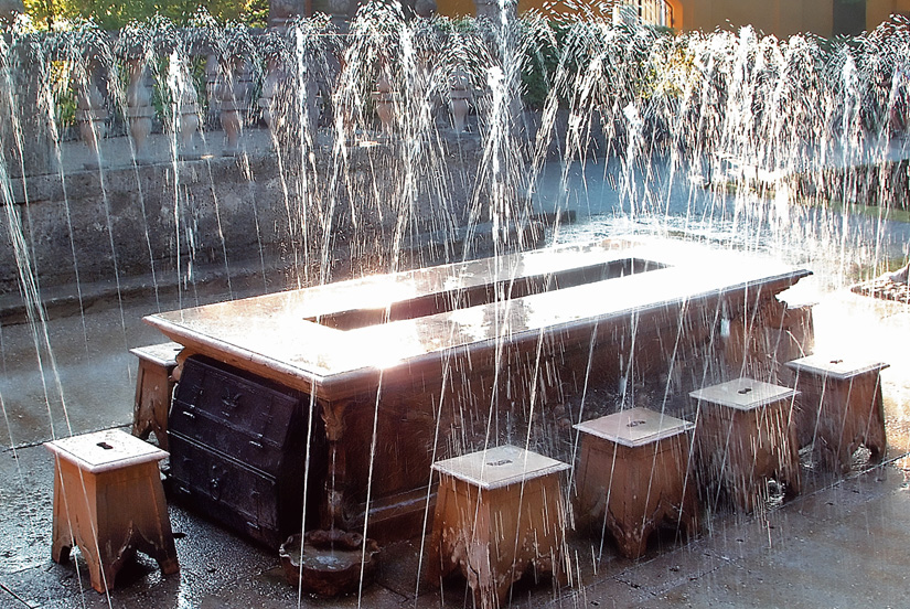 Wasserfontänen sprühen rund um einen Tisch